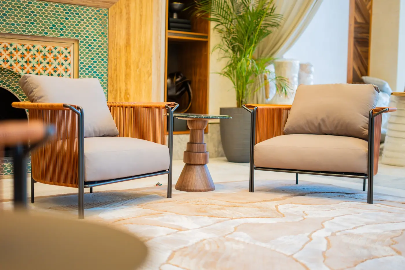 A pair of armchairs in a lounge with patterned tiles