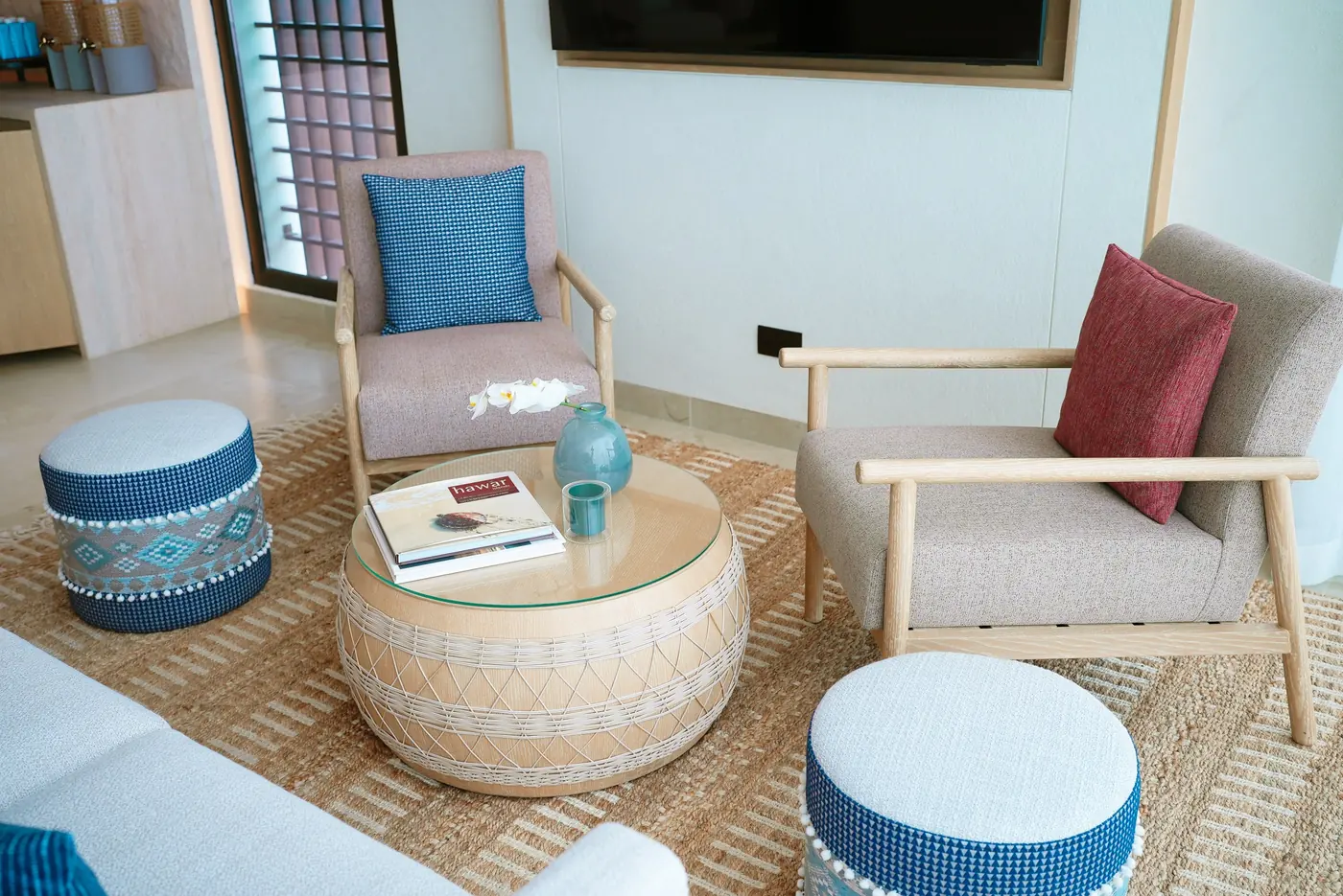 Woven ottomans and oak armchairs