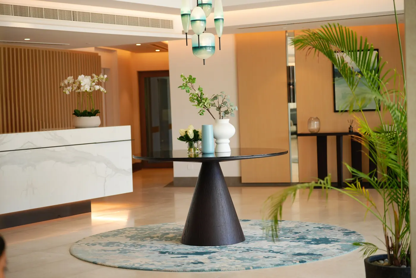 A reception with a sculpted table and a blue rug